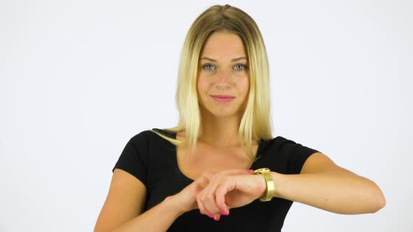 A Young Beautiful Woman Taps Her Watch and Nods at the Camera - White Screen Studio