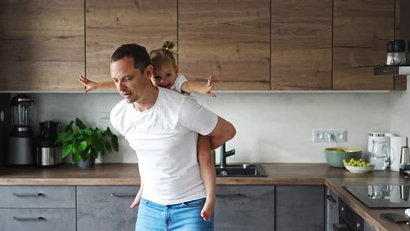 A Happy Father and Little Girl Joyfully Spending Time in a Modern Kitchen