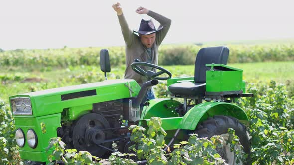 Young Happy Farmer Rejoices at His New Tractor