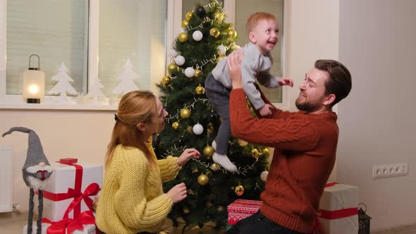 Happy Family Having Fun and Playing Together Near Christmas Tree