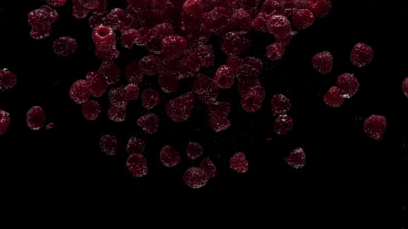 Slow Motion Raspberry Falling Into Transparent Water on Black Background