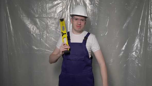 Builder in Blue Overalls and White Hard Hat Helmet and Protective Glasses