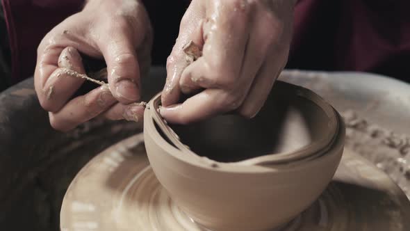 Potter Shapes the Clay Product with Pottery Tools on the Potter's Wheel Top View Toned Cinematic