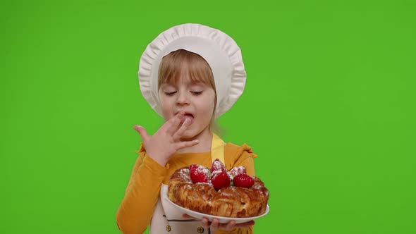Child Girl Kid Dressed As Professional Cook Chef Baker Eating Tasty Strawberry Pie on Chroma Key