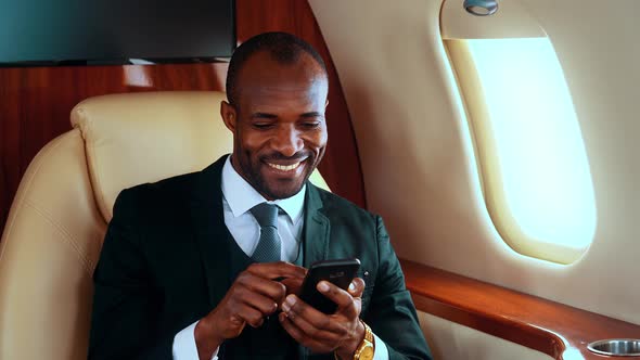 Successful entrepreneur usineg phone on his private jet