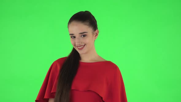 Portrait of Pretty Young Woman Is Looking Straight and Smiling. Green Screen