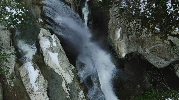 Waterfall Flowing From White Rocks Into a Lake in the Forest