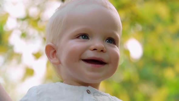 Close up of Blond Baby Smiling at Parents