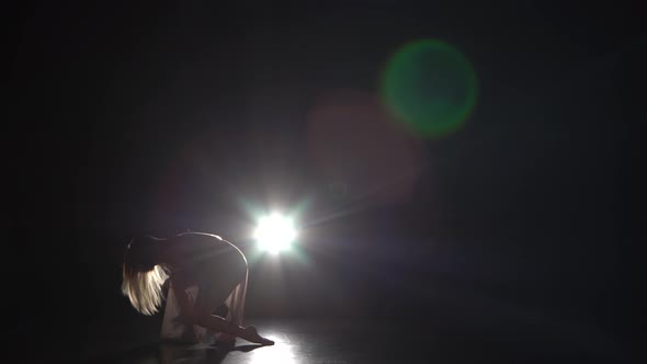 Graceful Girl Practicing Contemp in Dark Studio.