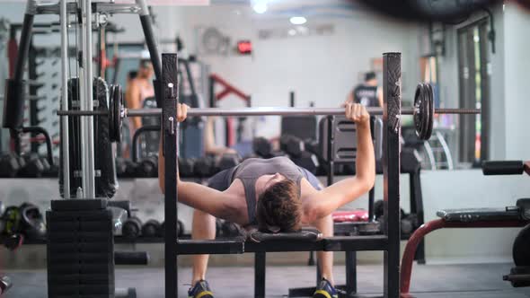 A Young Man Doing Bench Press Exercise in the Gym.