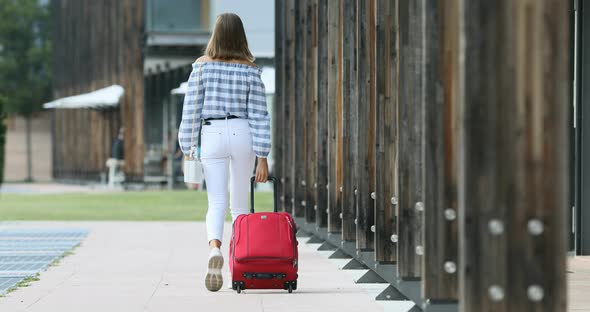 young woman is a tourist with suitcase walking somewhere in Europe