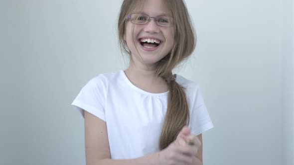 Kid Girl in Glasses Laughing at Funny Joke Looking at Camera