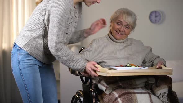 Female Volunteer Serving Dinner to Handicapped Old Women, Elderly Sitter Service