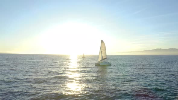 Aerial view. sailboat floats in water by beautiful sunset. 
