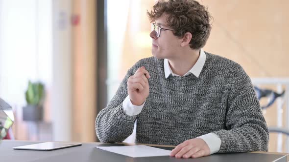 Young Young Man Writing on Paper at Work