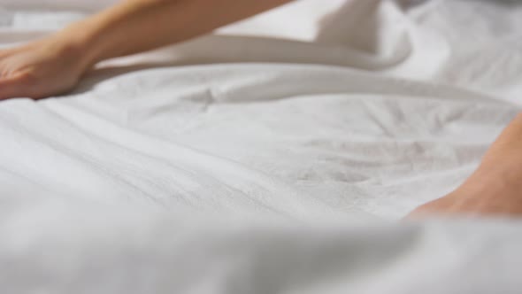 Hands of Woman Making Bed Linen