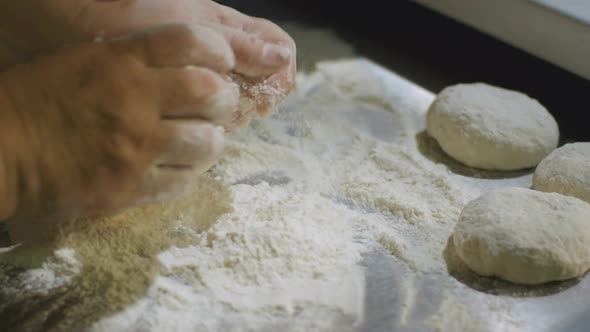 Closeup Human Hands Knead Dough on Board with Flour