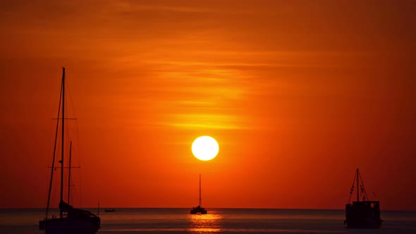 Sail boat in tropical sea at beautiful sunset or sunrise sky with Reflected sun on water surface