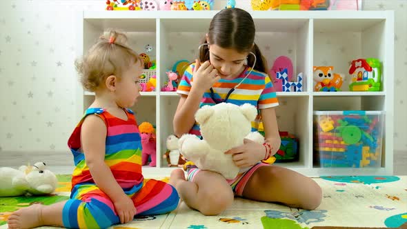 Children Treat a Teddy Bear Toy