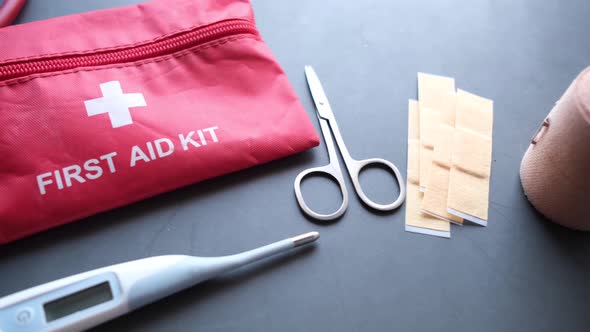 Close Up of First Aid Kit and Thermometer on Black