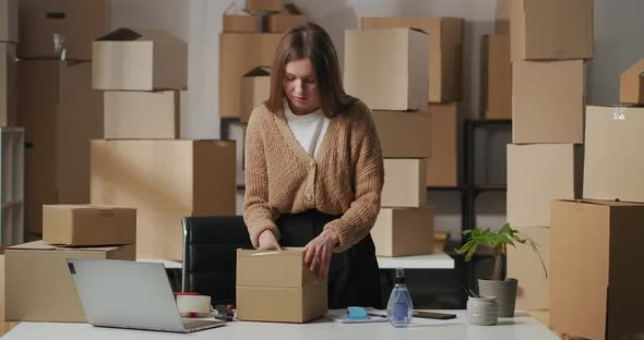 Woman Is Unpacking Box with Cosmetic in Home Warehouse Small Trading or Supplying Company Business