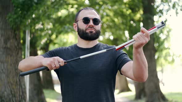 Blind Bearded Man Preparing White Cane for a Walk