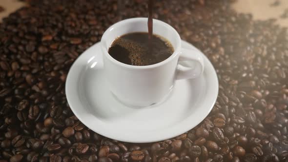 Coffee Cup and Coffee Beans. White Cup of Evaporating Coffee on the Table with Roasted Bean. Stock