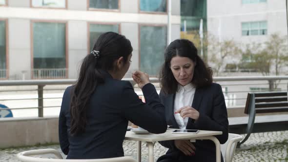 Businesswomen with Digital Tablet in Outdoor Cafe