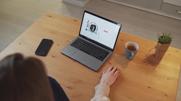 Female Sits at a Desk and Uses a Laptop Surfing the Internet a Woman Visits Online Stores Spending