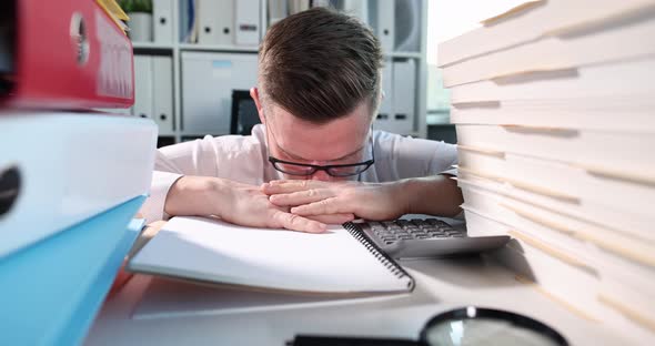 Young Businessman with Glasses Sleeps at Workplace and Wakes Up Abruptly