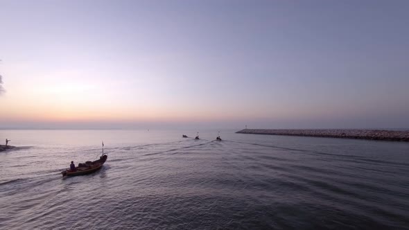 Aerial: Local fishermen of Thailand traveling to the open sea to fish - aerial