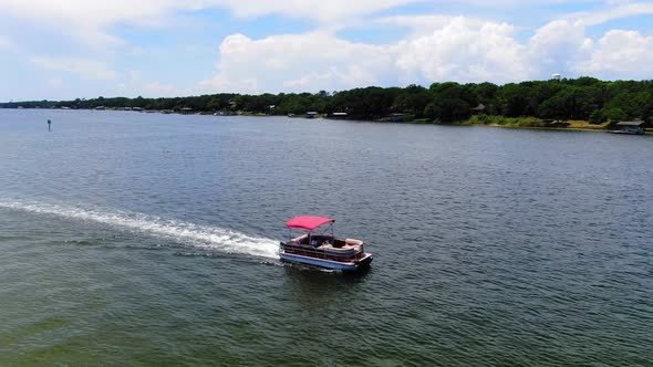 Pontoon boat cruising through the sound past some small islands near Destin Florida.