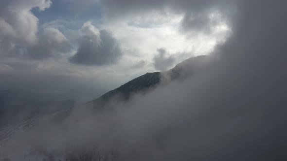 Heavy fog over the top of the mountain 4K drone footage