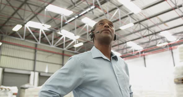 Close up of a male warehouse worker using headset in a storeroom 4k