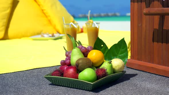 Close up detail of a fruit plate at a picnic on a tropical island beach.