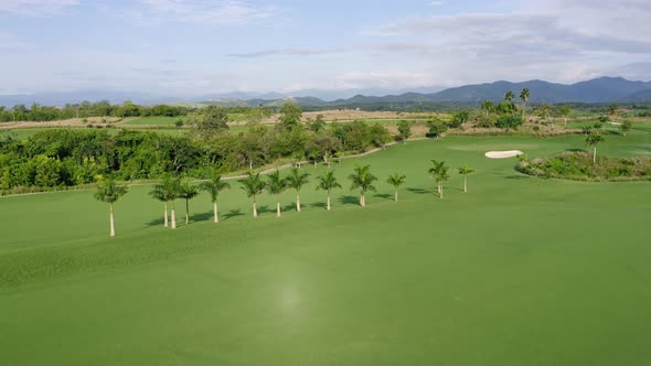 Aerial flyover beautiful tropical Golf Club with green tutored lawns during sunny day - Dominican Re