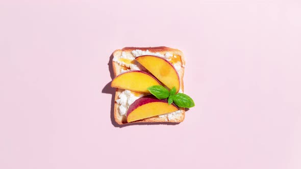 Set of toasted bread with peach, apple and banana on pink background. Stop Motion Animation.