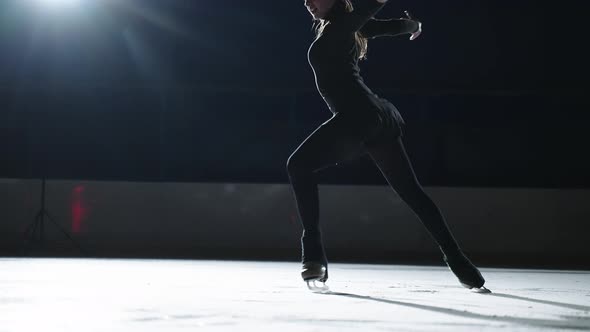 Slow Motion Cinematic Shot of Young Female Artistic Figure Skater is Performing a Woman's Single