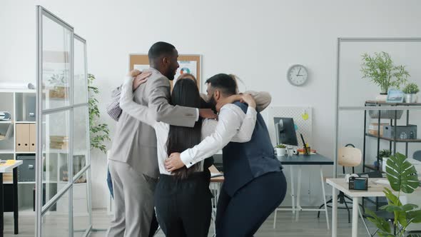 Multiethnic Group of People Collegues Jumping and Hugging Then Clapping Hands in Office