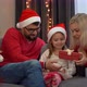 Family Open Gift Box with Magic Luminous Light Next to Christmas Tree at Home - VideoHive Item for Sale