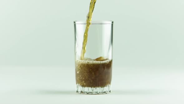 Cola Is Poured Into Glass Full of Bubbles and Foam Isolated on White Background Slow Motion