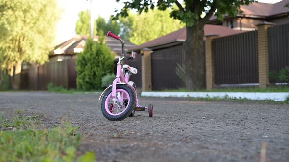 Children's bike stands on a country road waiting for a child