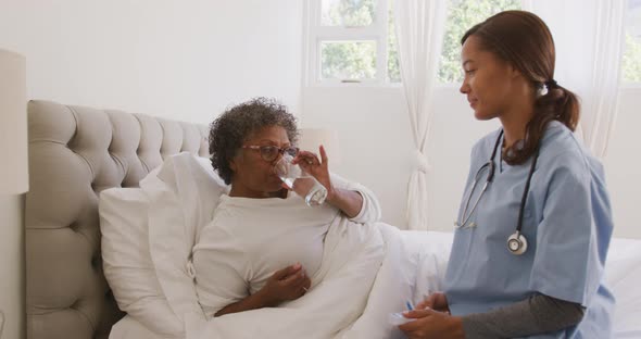 Mixed race woman being visited at home by a nurse. Social distancing and self isolation in quarantin