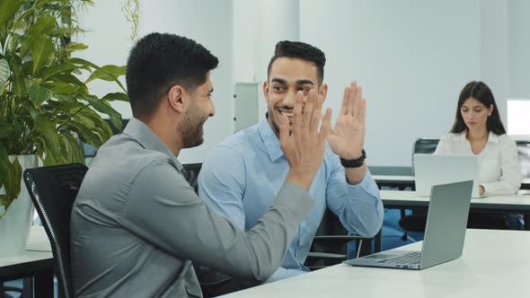 Happy Young Indian Oriental Employee Giving High Five to Skilled Smiling Arabic Millennial Male Boss