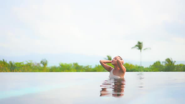 Young asian woman enjoy around outdoor swimming pool for leisure