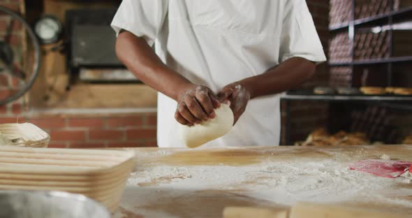 Animation of midsection of african american male baker preparing sourdough for bread