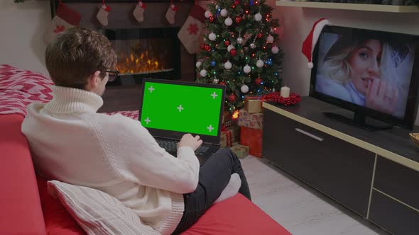 Man using laptop on Christmas holidays. Laptop Green Screen Chroma Key.