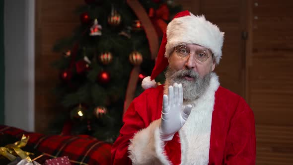 Portrait of Santa Claus Looking Pensively Around Makes Secret Gesture and Winks