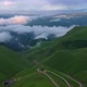 Drone Flight above green fields at the mountains in the clouds and fog - VideoHive Item for Sale