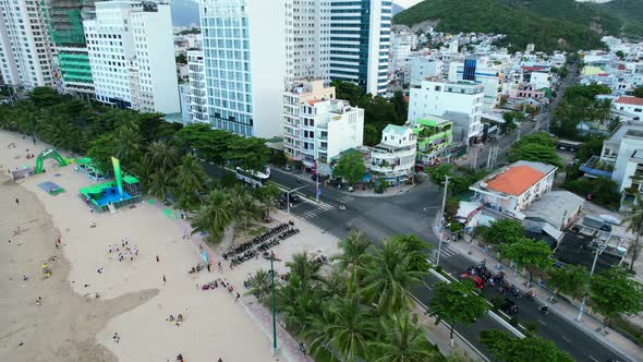 aerial top down view of a coastal road in nha trang vietnam with motorbikes and cars arriving at a t